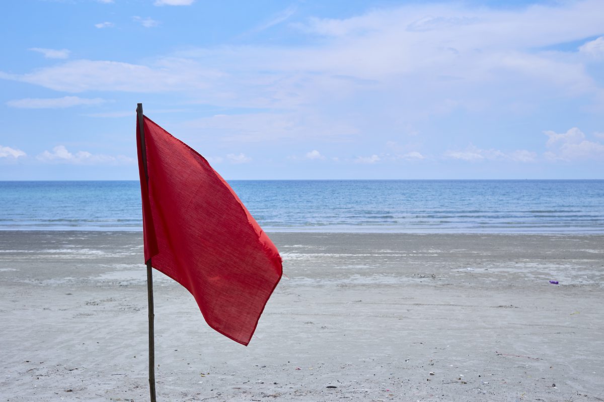 Red flag with the sea, Signal warning on the beach.