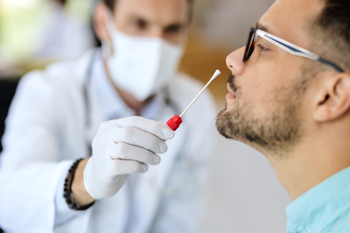 Close-up of young man getting PCR test at doctor's office during coronavirus epidemic.