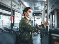 Image of  man in bus wearing medical face mask to protect corona virus Covid-19 virus, pollution, face masks traveling during global health emergency, bird flu, respiratory problem, viral pneumonia, SARS, illnesses, quarantine and diseases